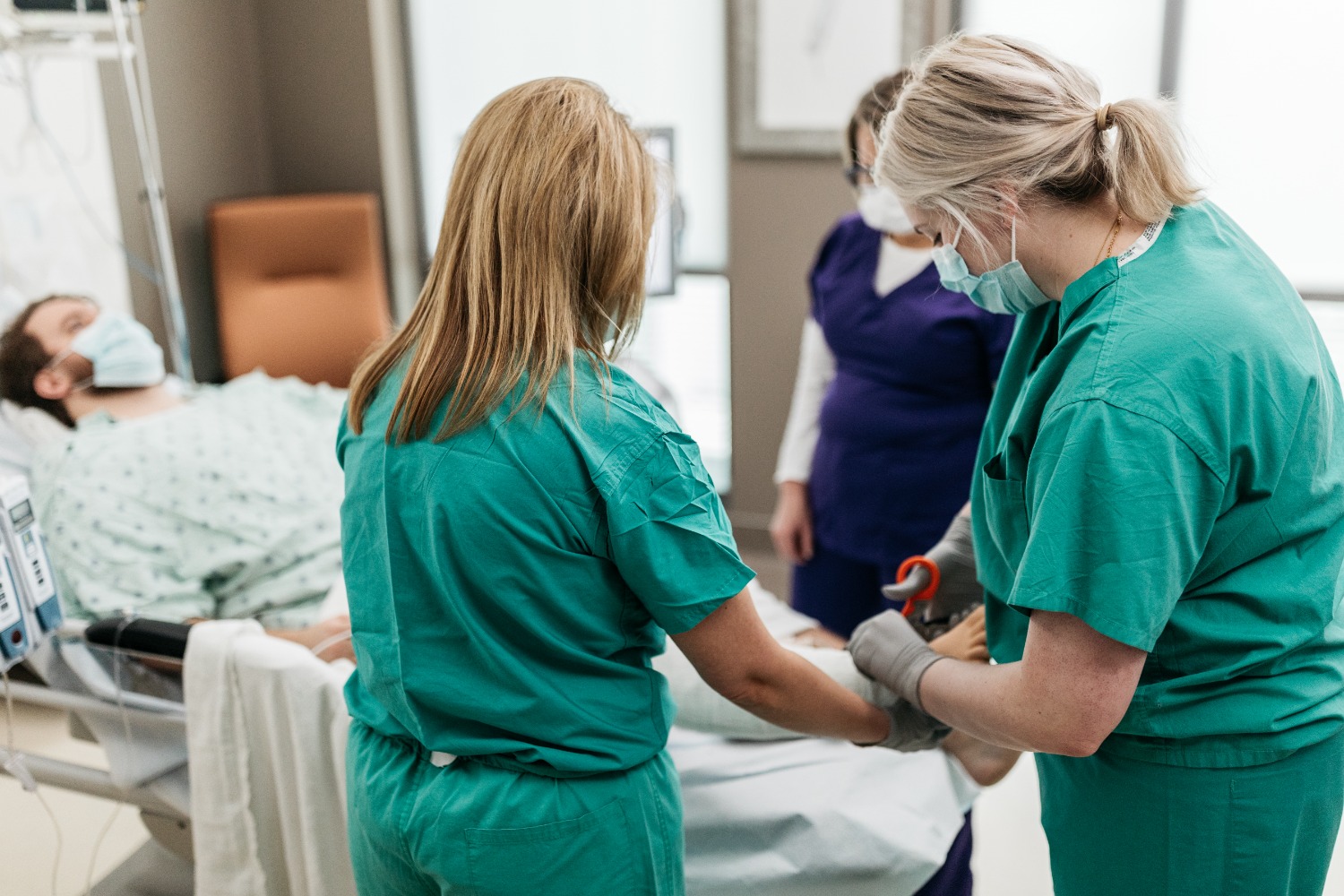 Three nurses caring for patient
